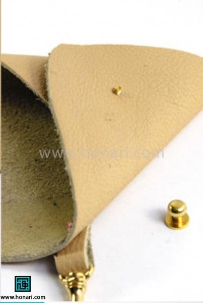 اموزش کیف چرمی مثلثی-مرحله 5 دو گوشه ی پایینی مثلث رو روی هم قرار می دیم به صورتی که سوراخ های پانچ شده روی هم قرار بگیرن و بعد قطعه ی پایینی دکمه رو از داخل سوراخ ها رد می کنیم