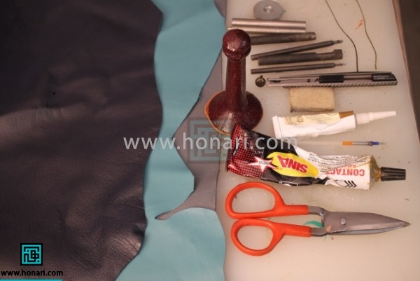 اموزش دستبند چرمی-مرحله 1 1.مواد و ابزار اولیه مورد نیاز برای شروع آموزش چرم دوزی : چرم مصنوعی آبی آسمانی و سرمه ای ، دکمه چهار پارچه میانه ، دو پایه ، نخ موم زده ، خمیر دورگیر طلایی ، تخته کار ایرانی ، کاتر سربی بزرگ ، فندک فشاری چسب آهن ، کرپ قهوه ای ، مشته بزرگ ، خودکار ژله ای ، خط کش فلزی ، دکمه زن میانه ، سمبه طرح اشک ، سمبه سایز یک ونیم و دو ، سوزن بزرگ ، قیچی مخصوص چرم ،