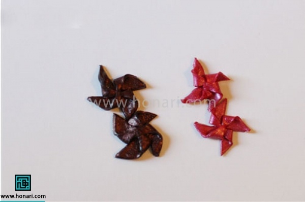 آموزش گوشواره خمیری با طرح فرفره-مرحله 4 یکی در میان ضلع های مثلث بوجود آمده را بر روی مرکز مربع تا میکنیم تا مانند فرفره شود.