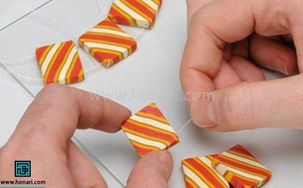 آموزش دستبند خمیری-مرحله 9 بعد از آنکه مانند دستور نوشته شده روی جعبه خمیر، آنهارا حرارت دادیم و سرد شد . کش نامرئی را از سوراخ ها رد میکنیم تا دستبندتکمیل شود