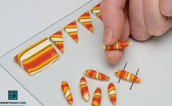 آموزش دستبند خمیری-مرحله 8 مثلث ها را نیز مانند مربع برش زده و با استفاده از انگشت شصت و اشارهرول میکنیم و در آنها نیز مانند مرحله قبل سوراخی ایجاد میکنیم