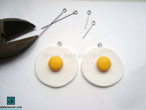 آموزش گوشواره خمیری با طرح گل-مرحله 3 دایره های زرد را در مرکز دایره سفید قرار میدهیم و قلاب های گوشواره را نصب میکنیم