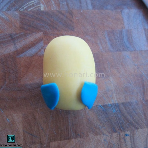 آموزش عروسک خمیری مینیون-مرحله 3 نیم دایره ها را به پهلوی بدنه اصلی متصل میکنیم