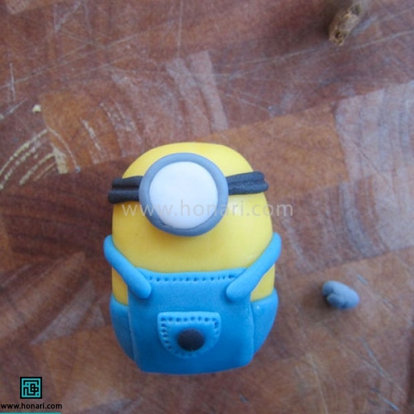 آموزش عروسک خمیری مینیون-مرحله 13 دایره سفیدیبرای چشم درست میکنیم،دور آن رول طوسی وصل میکنیم و در جای چشم قرار میدهیم