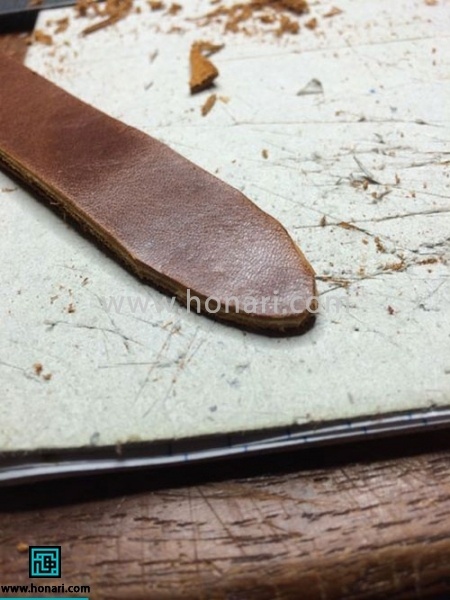 اموزش ساخت بند ساعت چرم-مرحله 2 یکی از نوار ها را از وسط تا کرده و سر آن را به شکل بالا در می آوریم.