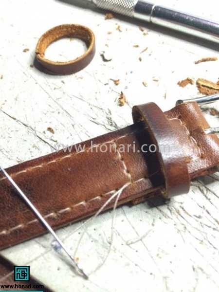 اموزش ساخت بند ساعت چرم-مرحله 11 بعد از قرار دادن سگک در جای خود ، ادامه چرم را ما بین دو تکه قرار داده ، حلقه بندگیر را نیز قرار میدهیم و شروع به دوختن بند چرمی میکنیم