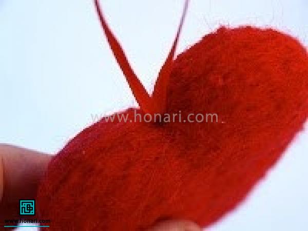 آموزش ساخت قلب با الیاف کچه دوزی-مرحله 10 با استفاده از سوزن مخصوص گره ربان را به داخل سوراخ ایجاد شده هدایت می کنید.سپس االیاف اطراف گره را سوزن می زنید تا گره در پشم محکم شود. به این ترتیب قلب نمدی ما آماده میشود . برای دیدن طرح های مختلف نمد دوزی و یا کچه دوزی میتوانید اینجا کلیک کنید .