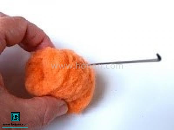 آموزش ساخت کدو تنبل با الیاف کچه دوزی-مرحله 2 هر چه رول کردن الیاف بهتر انجام شود فشرده کردن با سوزن راحت تر انجام می شود. انتهای رول را با سوزن زدن محکم کنید.