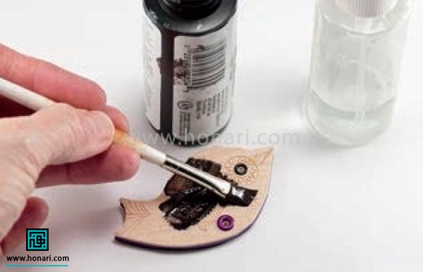 آموزش ساخت پیکسل با طرح پرنده-مرحله 13 با استفاده از شاپان یا رنگ روغن مشکی و قلم مو مقداری رنگ مشکی روی سطح کار می کشیم.