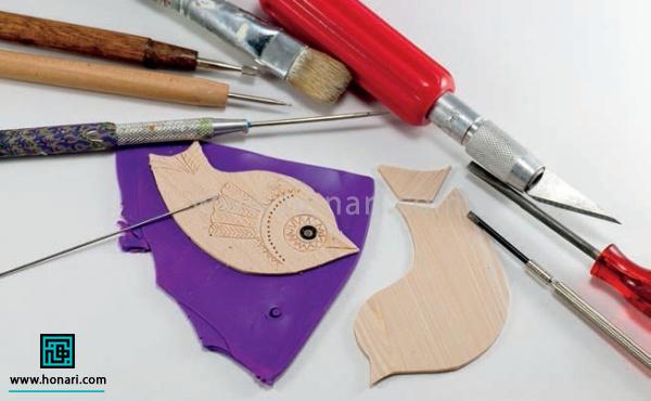 آموزش ساخت پیکسل با طرح پرنده-مرحله 8 یک لایه از خمیر بنفش رنگ رو با استفاده از وردنه باز میکنیم و پرنده رو بر روی اون قرار می دیم. بعد با استفاده از یک ابزار نوک تیز خطوط بدن پرنده رو روی اون رسم می کنیم.