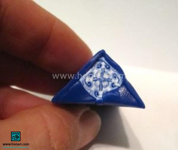 آموزش ساخت تخم مرغ رنگی با خمیر فیمو طرح دار-مرحله 5 برای ردیف بعدی یک برش مربعی ازخمیر طرح دار رو به این صورت در ترکیب با مثلثی از خمیر آبی تیره قرار می دیم و برش های یک میلی متری می زنیم.