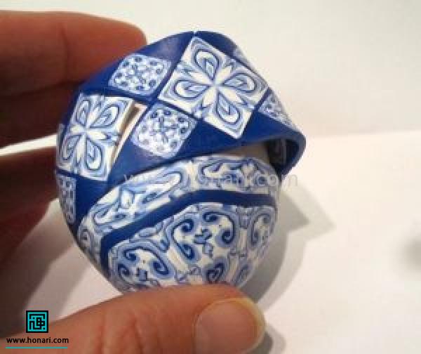 آموزش ساخت تخم مرغ رنگی با خمیر فیمو طرح دار-مرحله 7 و اون رو در ادامه ی ردیف های قبلی به تخم مرغ وصل می کنیم.