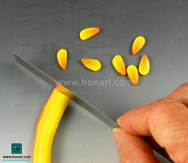 آموزش ساخت گل آفتابگردان با خمیر فیمو-مرحله 16 به کمک کاتر کارو به تکه های کوچیک برش بدین. برای هر گل به 16 گلبرگ نیازه.