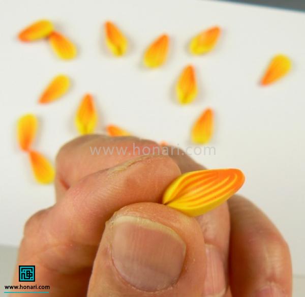 آموزش ساخت گل آفتابگردان با خمیر فیمو-مرحله 17 ابتدای گلبرگ رو کمی حالت بدین.