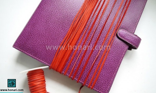 اموزش ساخت آویز چرمی -مرحله 2 حدود 12 متر تریشه را برش میزنیم و آن را دور کتاب یا وسیله ای که طولش 2برابر طول دلخواه منگوله ما باشد میپیچیم.