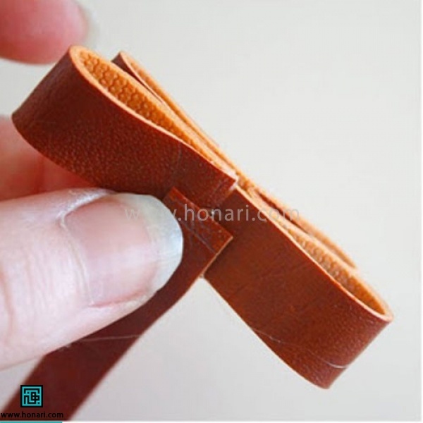 اموزش تل سر چرم دوزی پاپیون-مرحله 5 نواری به اندازه 5 در 1 سانتی متر از چرم برش میزنیم و در مرکز پاپیون میچسبانیم