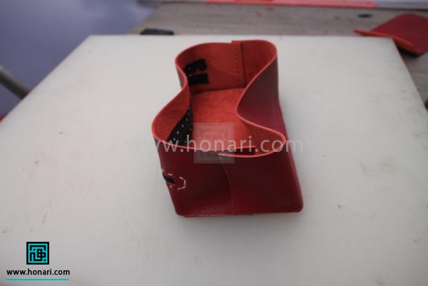 اموزش ساخت کیف لوازم آرایش چرم دوزی-مرحله 11 طرف دیگر نوار چرمی را هم سمبه زده دوخت بزنید.