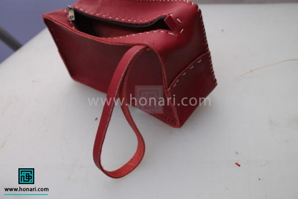 اموزش ساخت کیف لوازم آرایش چرم دوزی-مرحله 17 در صورت تمایل نوار باریکی از چرم را به اندازه ای که در تصویر دیده می شود به کار متصل کنید تا کیف شما دسته دار شود.