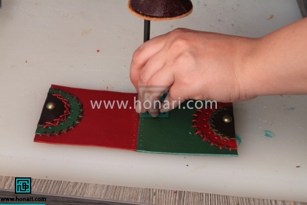 11.دو تکه چرم اصلی که بدنه کیف را تشکیل میدهد را با چسب به یکدیگر متصل کرده و با سمبه سوراخ میکنیم.