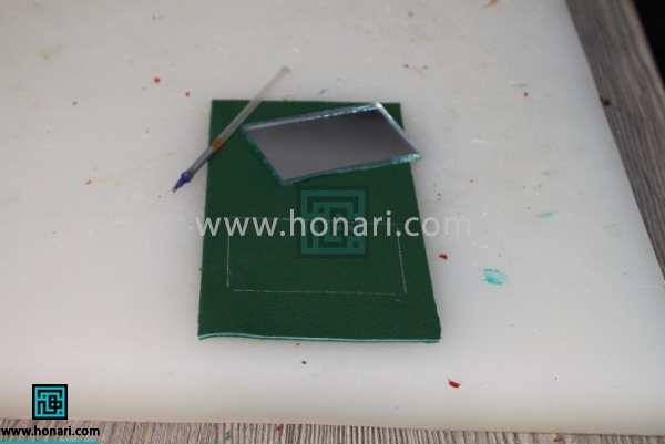 13.با استفاده از خودکار اکلیلی نقره ای جای اینه را روی کیف مشخص میکنیم.