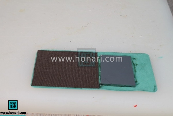 16.از پشت قطعه ی استر بریده شده ای به اندازه نصف قسمت داخلی کیف اینه را به کار می چسبانیم.