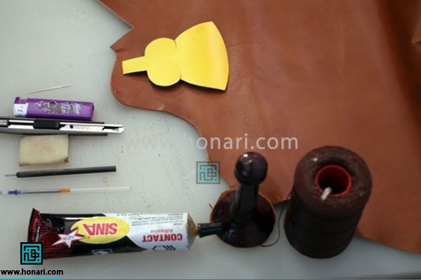 1.مواد و ابزار اولیه مورد نیاز برای شروع آموزش چرم دوزی : چرم مصنوعی قهوه ای سوخته ، نخ موم زده ، رنگ ویترای مشکی ، حلقه کلید معمولی ، تخته کار ایرانی، چسب آهن کرپ قهوه ای ، مشته بزرگ ، خودکار ژله ای ، سمبه سایز یک و نیم ، سوزن بزرگ ، قیچی چرم ، فندک فشاری 