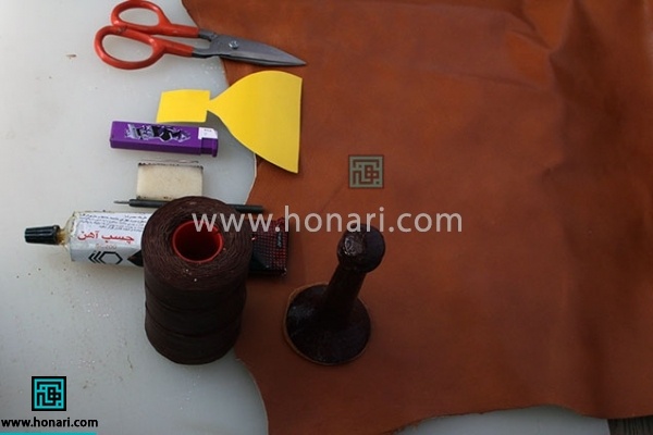 1_ مواد وابزار اولیه مورد نیاز برای شروع آموزش چرم دوزی : چرم مصنوعی ، نخ موم زده ، رنگ ویترای مشکی ، حلقه کلید معمولی ، تخته کار ایرانی ، چسب آهن کرپ قهوه ای ، مشته بزرگ ، خودکار ژله ای ، سمبه سایز یک و نیم ، سوزن بزرگ ، قیچی مخصوص چرم ، فندک فشاری 