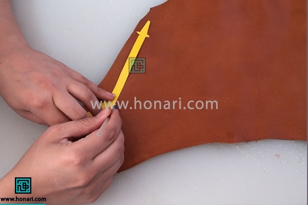 2.الگو را با خودکار نقره ای روی چرم مصنوعی پیاده میکنیم 