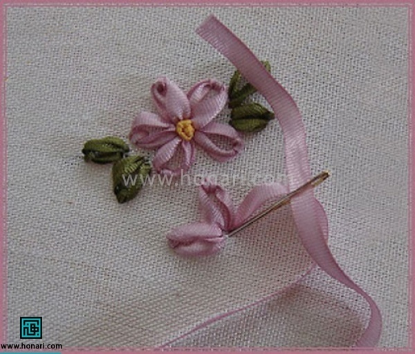 روبان نیم سانتی یا یک سانتی را با استفاده از سوزن های مخصوص روبان دوزی از پارچه بیرون میکشیم و دوباره در جای اول سوزن را در پارچه فرو میکنیم 