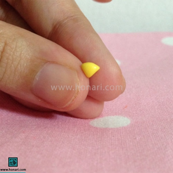 حال با استفاده از خمیر زرد یا نارنجی ، یک مثلث برای منقار جغد درست میکنیم