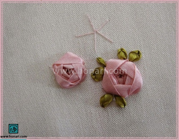 اضافه روبان را در هر جایی که کوک معلوم نبود همانجا در پارچه فرو کنید .برای زیبا تر شدن کار با روبان رنگ سبز دوخت شلال بزنید به عنوان برگ