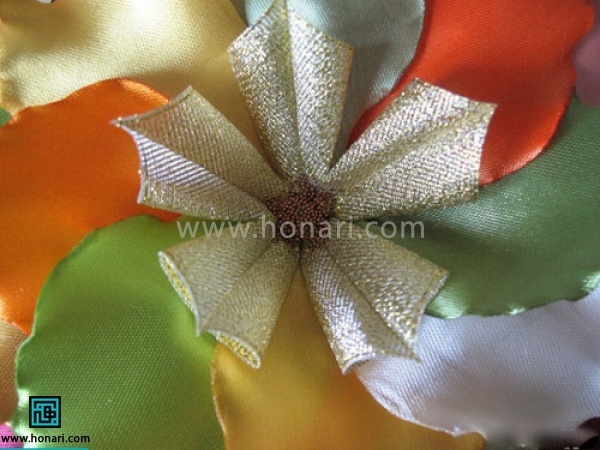 گلبرگ های اماده شده را در مرکز بگزارید و با چسب تفنگی سر جایش وصل کنید