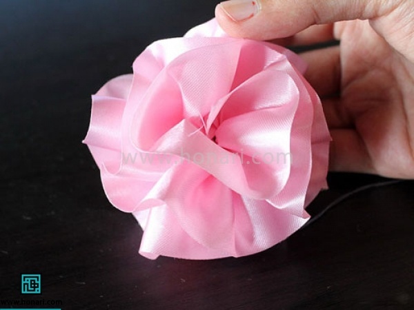 ته نخ را گره زده و روبان را دور خود بپیچید تا شکل گل بگیرد