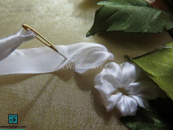 گل را کامل کنید و دور مرکز گل نزدیک به هم شلال بزنید. 
برای غنچه کار دوخت شلال را میزنید با این تفاوت که سوزن را مطابق شکل روی خود روبان فرو کنید.