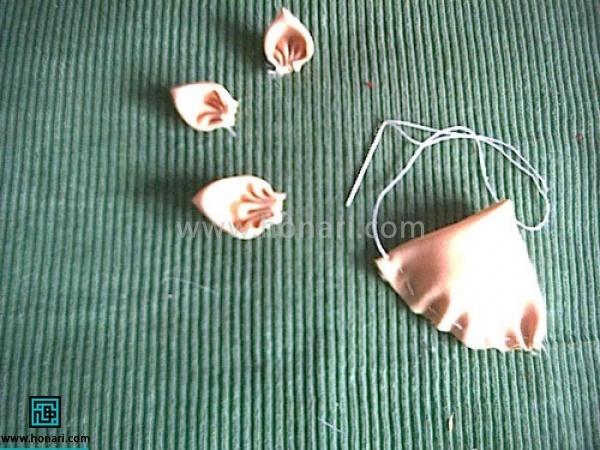 روبان پهن را به صورت دایره ببرید. دایره را دو بار از وسط تا کنید تا شکل مثلث بشود و پایین مثلث را کوک بزنید و نخ را بکشید تا جمع بشود و شکل گلبرگ بشود. ته نخ را گره بزنید

