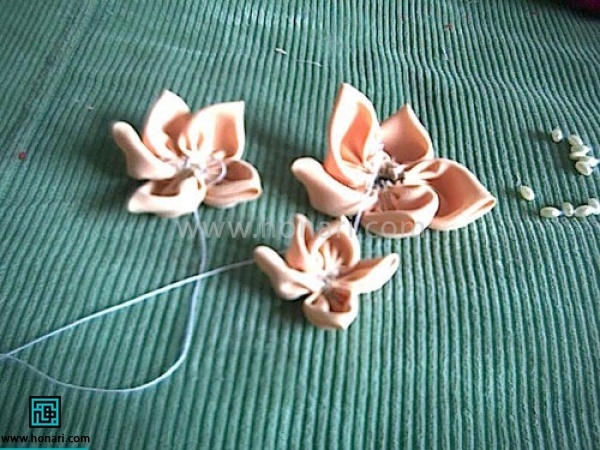 گلبرگ های نخ کشیده شده را دور خودش بپیچید و کمی نخ را بکشید تا بهم منسجم شوند