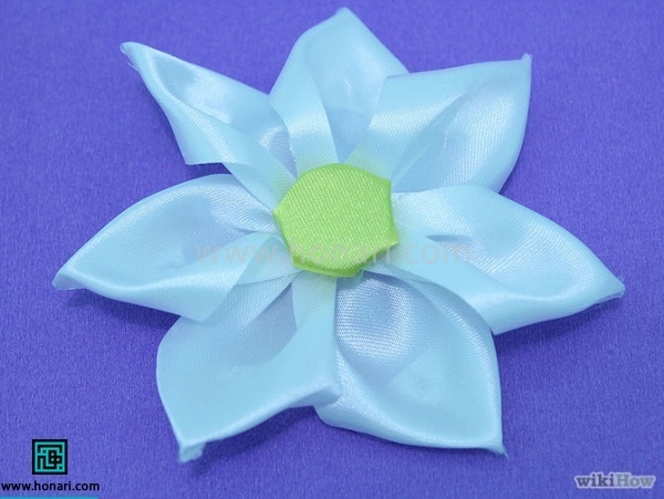 برای مرکز گل یک روبان را گرد کنید دور روبان را کوک بزنید و کوک را کمی بکشید تا روبانی که گرد بریده بودید کمی حالت پف دار پیدا کند