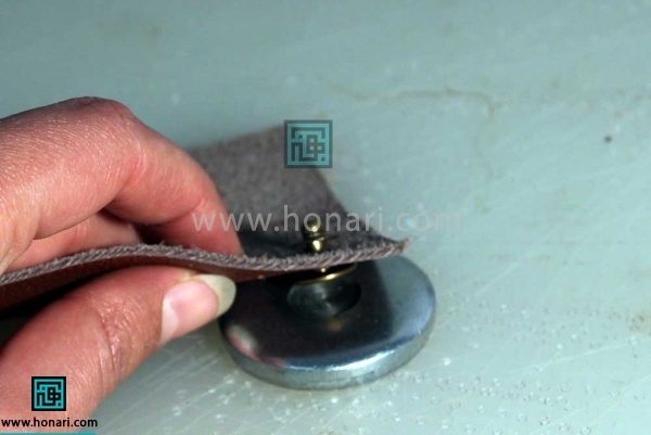 اموزش نصب دکمه ی چهار پارچه در چرم دوزی -مرحله 8 آنرا برسندان دایره ای مخصوص چرم قرار دهید به گونه ای که قسمت دایره ا ی جزاول در فرو رفتگی دایره ای سندان قرار گیرد