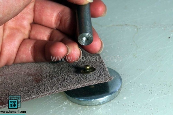 اموزش نصب دکمه ی چهار پارچه در چرم دوزی -مرحله 9 سپس ازسمت داخل چرم به صورتی که در تصویر دیده می شود با ابزار دکمه زنی که دارای گودی است استفاده کرده