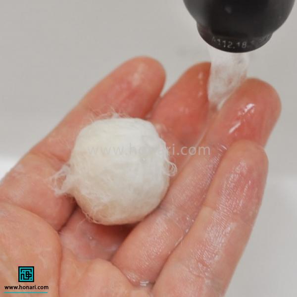 با اضافه کردن صابون، و رول کردن آن بین دو دست لایه اضافه شده به توپک متصل می شود