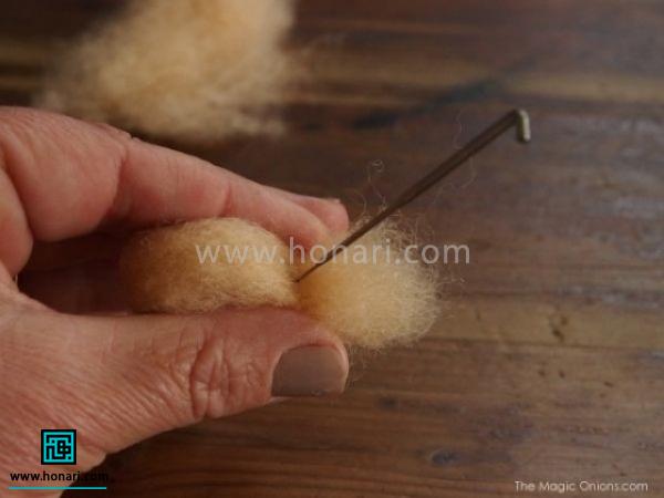 همانطور که بین دو انگشت نگه داشته اید دوسر الیاف روی هم آمده را سوزن می زنید. 