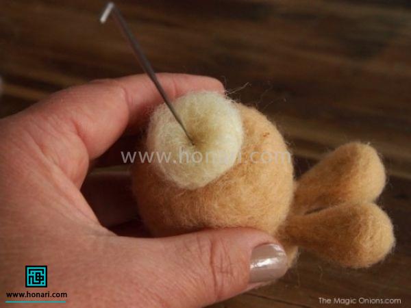 برای ساختن دم خرگوش یک مقداری الیاف کرم را داخل دست گرد کرده و با سوزن زدن به بدن متصل می کنیم 