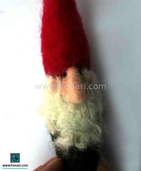 مقداری از الیاف موج دار سفید رنگ را برای مو و ریش دور سر و روی پایه ریش را با سوزن زدن محکم کنید دقت کنید ما بین گوش و چشم هم باید کمی از الیاف ریش قرار بگیرد 