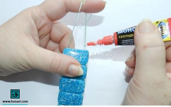 انتهای نخ را گره زده و با چسب قطره ای محکم می کنیم.